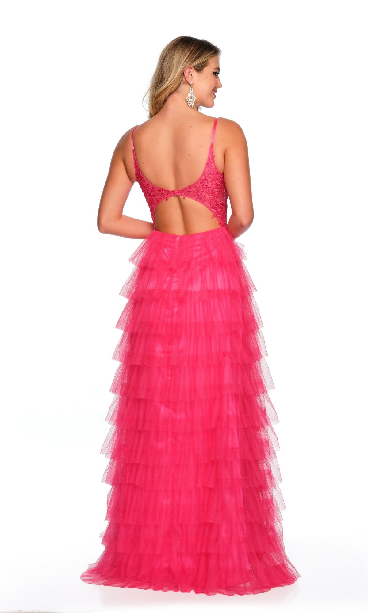 A woman stands against a white background wearing the Dave and Johnny Long Tiered Prom Dress 11148, featuring a sleeveless, bright pink design with an open back and lace v-neck bodice.